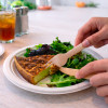 Assiette avec quiche et salade et couvert en bois