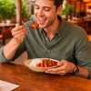 Homme qui mange repas dans un restaurant en bord de mer