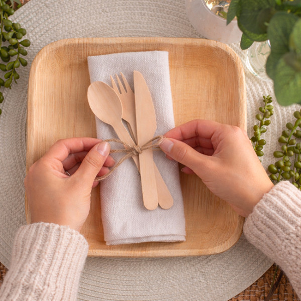 Disposition couvert en bois sur une assiette en palmier
