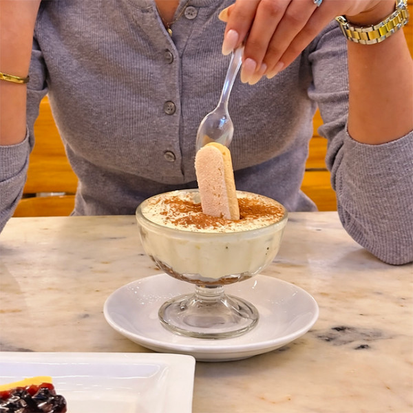 Femme qui mange un tiramisu avec une cuillère en plastique