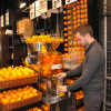 Personne qui se sert du jus d'orange dans un supermarché
