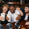 groupe d'ami au bar qui bois des bières dans des gobelets en car