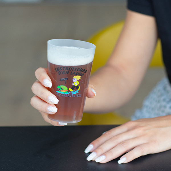 Personne qui boit dans un gobelet réutilisable personnalisé en couleur