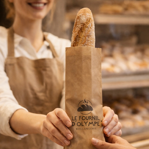 Boulangerie vente d'une baguette tradition dans un sachet kraft personnalisé