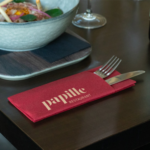 Mise en place de table: plat, couverts et serviette en pochette bordeaux personnalisé
